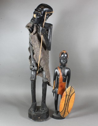 A carved African figure of an old man together with 1 other figure of a Maasai warrior, largest 28"h