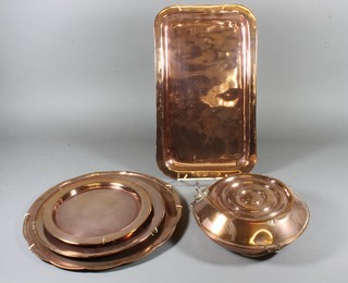 A circular copper foot warmer 8.5", 3 circular copper trays and a rectangular copper tray