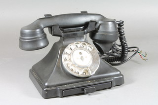 A black Bakelite telephone, the base marked 1/323L