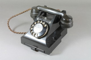 A black Bakelite dial telephone, the base marked 312L PL.57/3A