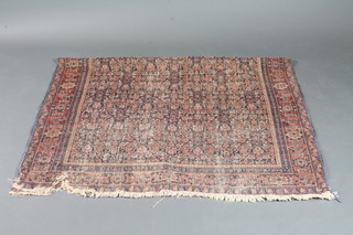 A 19th Century green and red ground Persian rug with all over  floral design within multi row borders, 79" x 52", worn,