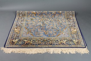 A contemporary blue ground North West Persian silk rug with tree and animal design to the centre, signed, 69" x 59"