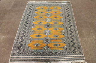 An Afghan part silk Bokhara carpet, the orange ground field decorated 14 geometric elephant pad motifs, multi bordered and  fringed, signed to end border 76"l x 51"w