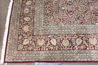 A contemporary red ground Pakistan wool rug, the central field decorated urns and flowers, signed 122" x 94"