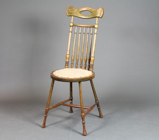 An Art Nouveau beech wood stick and rail back dining chair with upholstered seat, on turned supports united by an H framed  stretcher