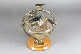 An aircraft altimeter? contained in a perspex cube mounted within a brass gimbal