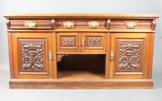A Victorian carved walnut sideboard fitted 3 long drawers above  a double cupboard with recess beneath, flanked by a pair of  cupboards enclosed by heavily carved doors, on a platform base  37"h x 71"w x 24"d