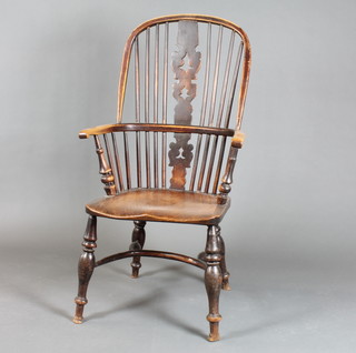 An 18th/19th Century beech and elm Windsor kitchen chair with solid seat, crinoline stretcher, raised on turned supports