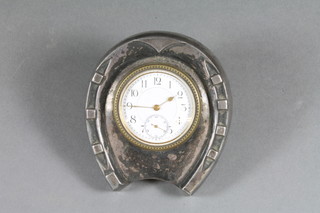 A Victorian travelling clock with enamelled dial and Arabic numerals contained in a silver horse shoe shaped case with  travelling case, Birmingham 1897