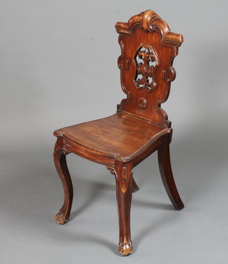 A mid 19th Century mahogany hall chair in the Gothic taste  having carved and pierced cartouche back above a solid seat,  raised on cabriole legs with scroll feet