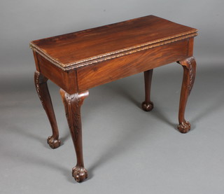 An early George III mahogany tea table, having a foliate carved hinged top, raised on acanthus leaf carved cabriole legs with claw  and ball feet 29"h x 36"w x 34"d