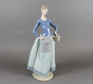 A standing Nao figure of a lady with basket and rabbit 13"