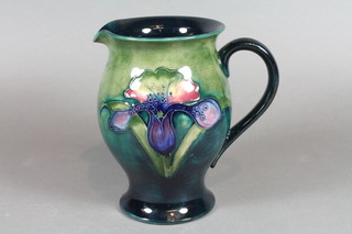A William Moorcroft green glazed Orchid pattern jug, the base with signature mark and impressed Moorcroft 6"