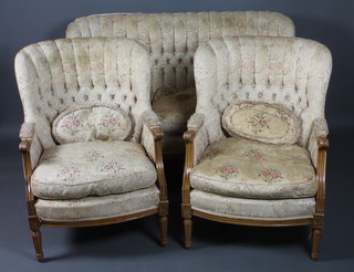 An early 20th Century 3 piece walnut salon suite in the 19th  Century taste, comprising 2 scallop backed open arm chairs and a  2 seat settee, having foliate tapestry woven upholstery, acanthus  leaf carved scrolled arms and raised on fluted tapered legs