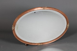 A 20th Century copper and brass mounted oval wall mirror inset bevelled plate with foliate cast decoration 32.5"h x 23.5"w