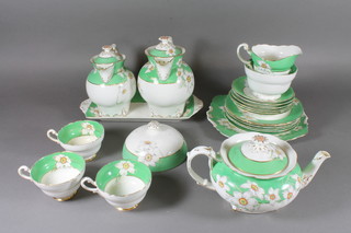 A Paragon 22 piece Narcissus green banded and floral patterned tea service comprising bread plate 9", 6 tea plates 7", rectangular  plate 12", teapot - lid f and r, 2 hot water jugs - 1 with chip to  interior rim, cream jug - cracked, sugar bowl, 6 saucers, 3 cups -  2 cracked, muffin dish lid 5.5"