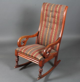 A Victorian mahogany rocking chair with modern blue and red striped upholstery, scroll arms, raised on baluster turned legs and  rockers