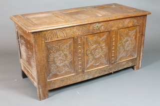 An 18th Century oak coffer of panelled construction, with later foliate and lunette carving, on end stiles 50"w x 23 1/2"d x 26"h