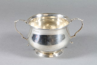 A silver twin handled sugar bowl of baluster form raised on a circular spreading foot, Birmingham 1914, 3 ozs