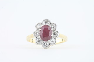 An 18ct yellow gold dress ring set an oval cut ruby surrounded  by diamonds