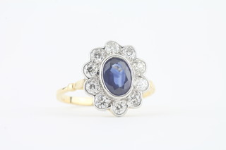 An 18ct yellow gold dress ring set an oval sapphire surrounded  by diamonds