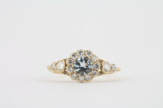 An 18ct yellow gold dress ring set an aquamarine surrounded by diamonds