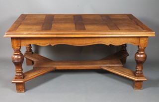An oak drawleaf extending dining table, having moulded top above a shaped apron raised on inverted baluster supports united  by shaped and moulded stretchers, block feet 31"h x 107"l x  40"d