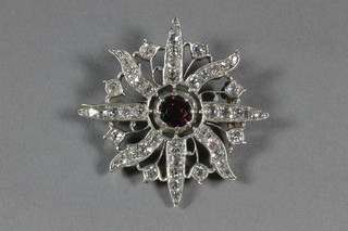 A gold brooch in the form of a star set sapphire to the centre, surrounded by diamonds, approx 1.2ct