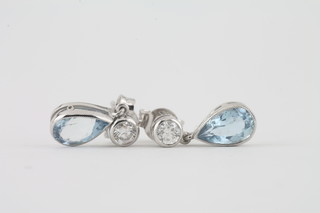 A pair of 18ct white gold earrings set tear drop aquamarines supported by diamonds