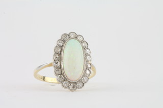 An 18ct yellow gold dress ring set an oval cabouchon cut opal surrounded by diamonds