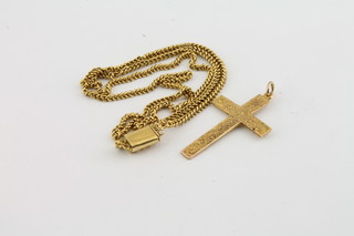 A yellow metal cross together with a yellow metal chain