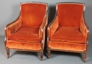 A pair of 19th Century French walnut bergere armchairs, the  reeded frames foliate carved with acanthus leaves, dralon  upholstery and raised on turned tapered reeded legs