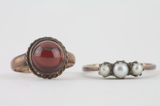 A 9ct gold dress ring set a circular cabouchon cut red stone and a gold dress ring set demi-pearls
