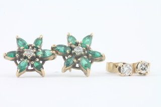 A pair of 9ct gold star shaped ear studs set emeralds and  diamonds and a pair of diamond set ear studs