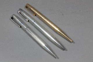 A silver ballpoint pen with engine turned decoration together with a propelling pencil and a Parker pen contained in a rolled gold  case