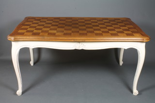 A French cream painted and oak drawleaf extending dining table in the Louis XV style, having a shaped parquetry top above a  moulded and carved frieze, raised on cabriole legs, scroll feet,  30"h x 117"w x 38"d