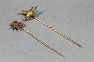 A gold and enamel stick pin in the form of a duck in flight and a pierced Chinese stick pin