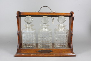 An oak and cut glass 4 bottle tantalus, 1 decanter chipped,