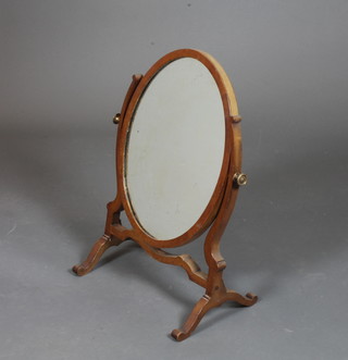 An Edwardian mahogany toilet mirror, the oval plate with scroll supports, raised on splayed legs 23"h x 17"w