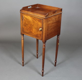 A George IV mahogany night table having a galleried top above a cupboard door, raised on ring turned tapered legs, peg feet 35"h  x 17"w x 14.5"d