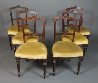 A set of 6 late Victorian walnut dining chairs with foliate carved  cresting rails and splats, stuff over seats, on ring turned fluted  tapered legs
