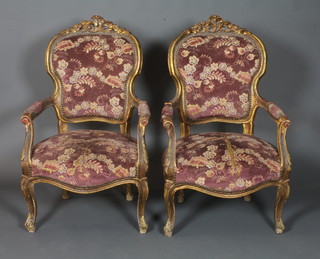 A pair of 19th Century French gilt wood fauteuil in the Louis XV style, having foliate moulded and carved frames, part padded  backs and arms above a stuff over seat, raised on cabriole legs