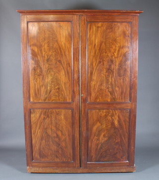 A 19th Century mahogany linen press with later moulded cornice  above 2 fielded panelled cupboard doors enclosing 5 linen shelves  and a single drawer, raised on plinth base, 73"h x 53"w x 25"d