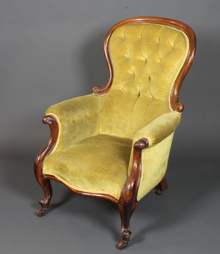 A Victorian mahogany framed spoon back open arm chair with  buttoned green dralon upholstery, raised on cabriole legs and  casters