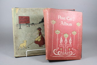 A red card album of postcards together with a 1930's scrap book  and a stamp album