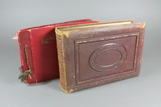 A Victorian leather photograph album containing family portraits  and 1 other album containing a small collection of photographs  and postcards