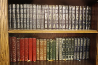 A large collection of leather bound volumes including famous  19th Century novels, the Literary Heritage collection by Heron  Books, London, Ernest Hemingway the first 49 stories published   by Franklin Library and sundry volumes