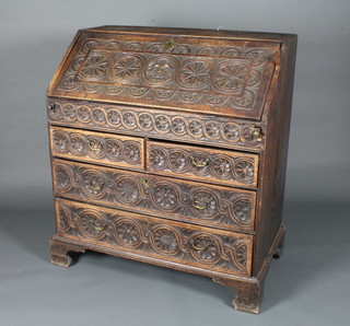 A George II oak bureau, later carved, the fall enclosing a fitted interior with well above 2 short and 2 graduated long drawers,  raised on shaped bracket feet 40.5"h x 36"w x 21"d