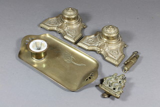 A brass trench lighter, a rectangular Art Nouveau brass ink stand with well, 2 brass ink wells and a brass door knocker