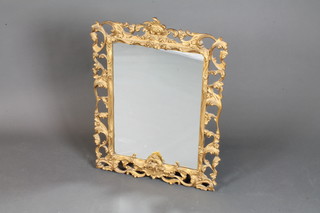 A rectangular plate mirror contained in a decorative carved gilt frame 31"h x 22"w